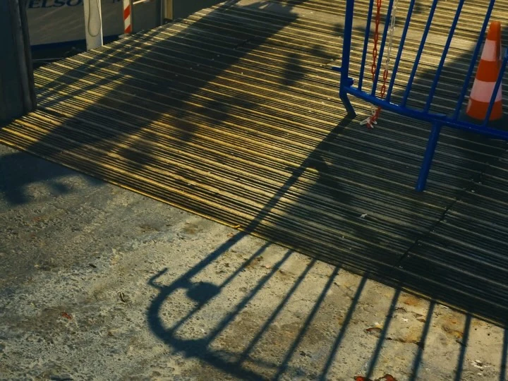 Bicycle shadows across sunlit paving