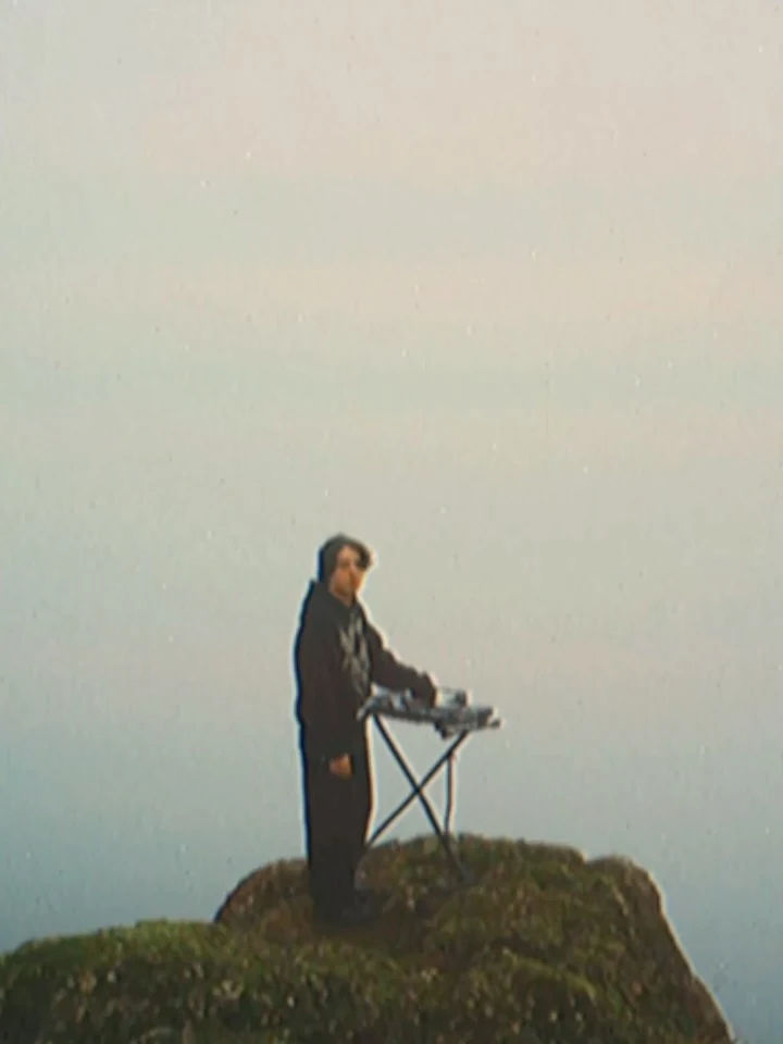 Noah standing with a keyboard in an open landscape