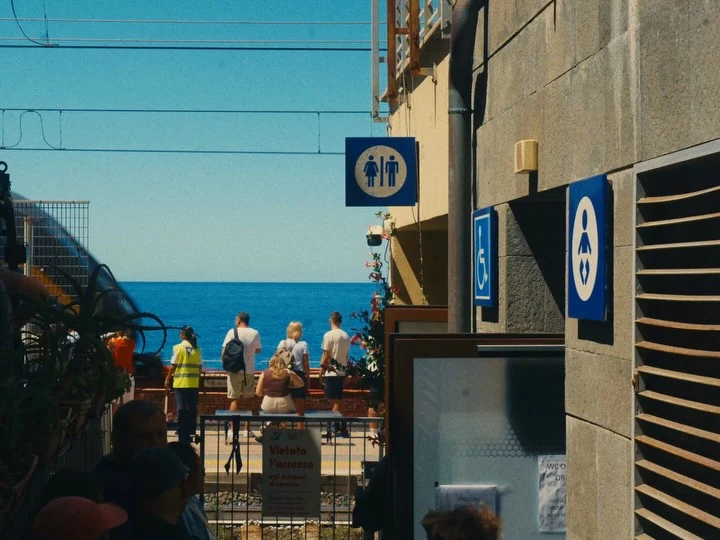 People beside the sea, framed by a dark foreground