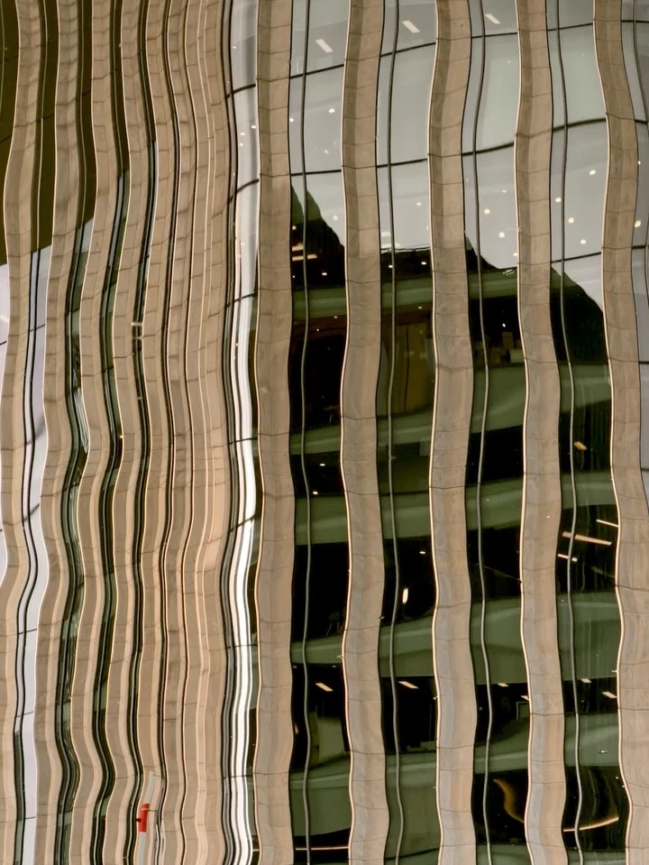A facade reflected in wavy vertical lines