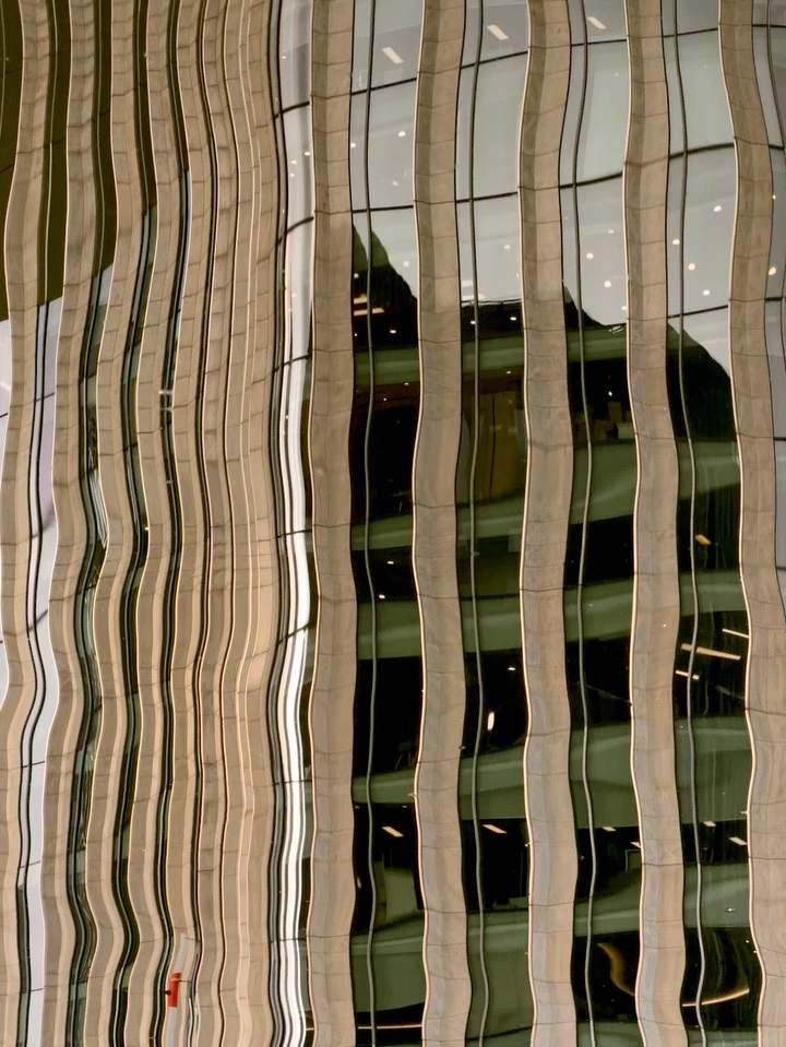 Cream and dark windows bent into waves by reflections