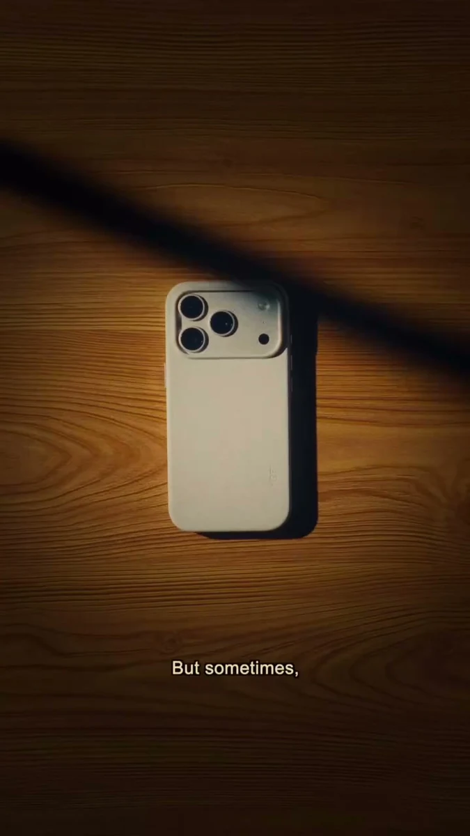 An iPhone resting on a wooden desk