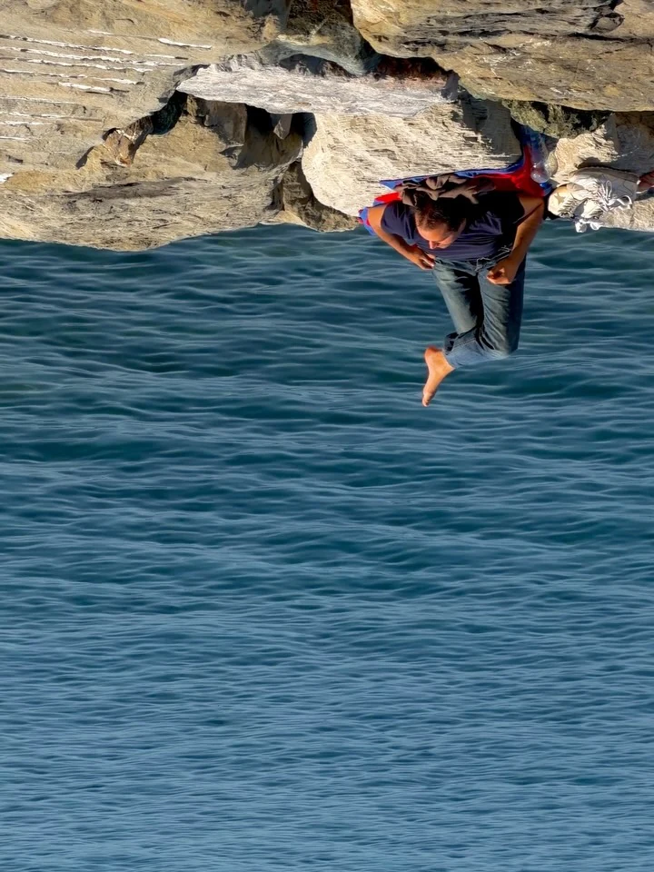 A person diving above blue water