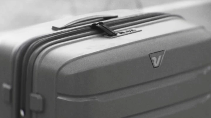 A monochrome close view of the sculpted shell and handle of a Roncato suitcase