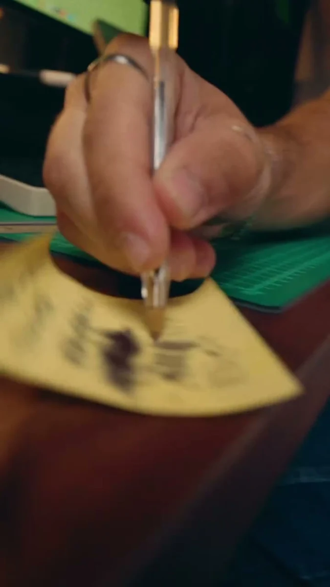 A hand writing on an Analog card
