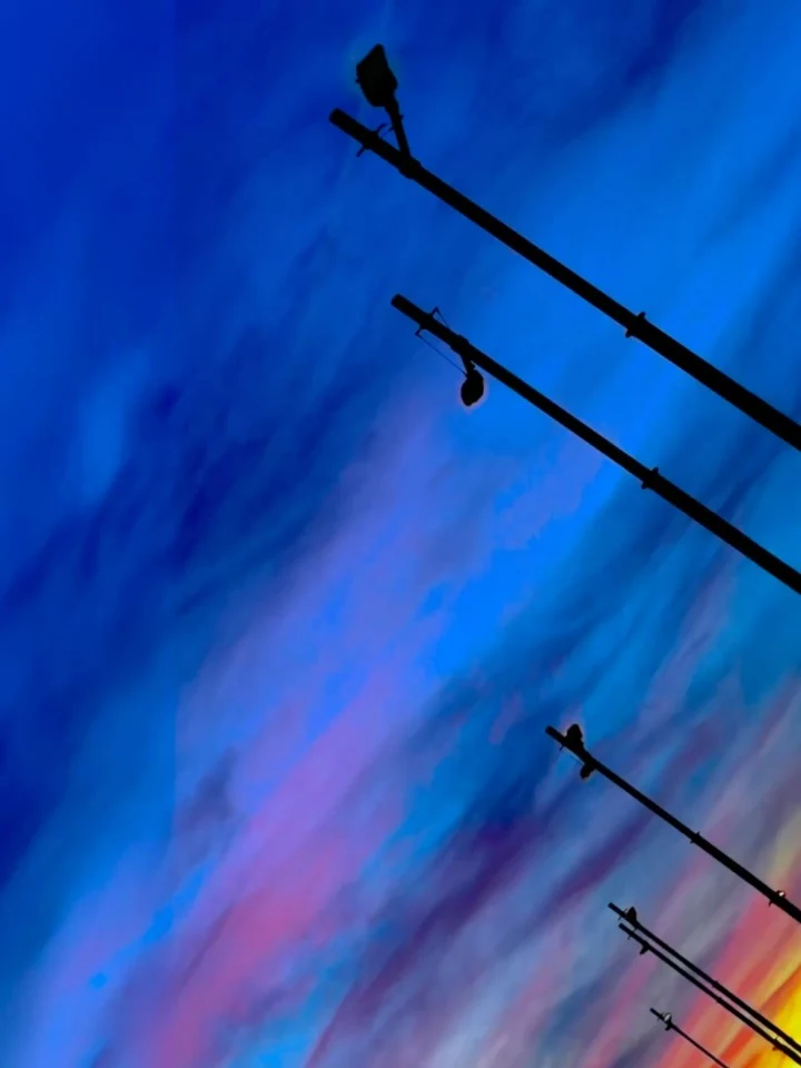 Street lamps receding across a deep blue sky