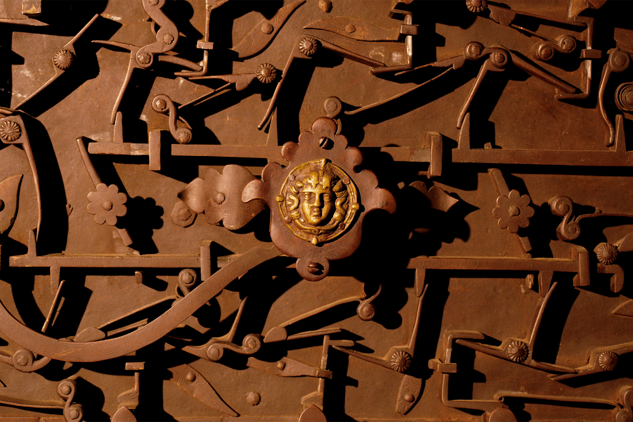 Ornate iron decorative detail with gilded Medusa face